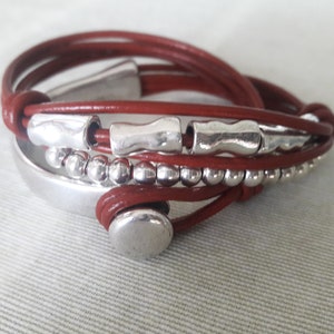 May include: A brown leather wrap bracelet with silver beads and metal accents.