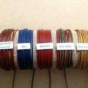 May include: Nine spools of leather cord in various colors, including distressed brown, light brown, blue, brick red, kinte gypsy, distressed mustard, and petal pink. Each spool is labeled with the color and description.