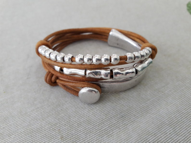 May include: A brown leather wrap bracelet with silver beads and metal accents.