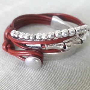 May include: A brown leather wrap bracelet with silver beads and metal accents.