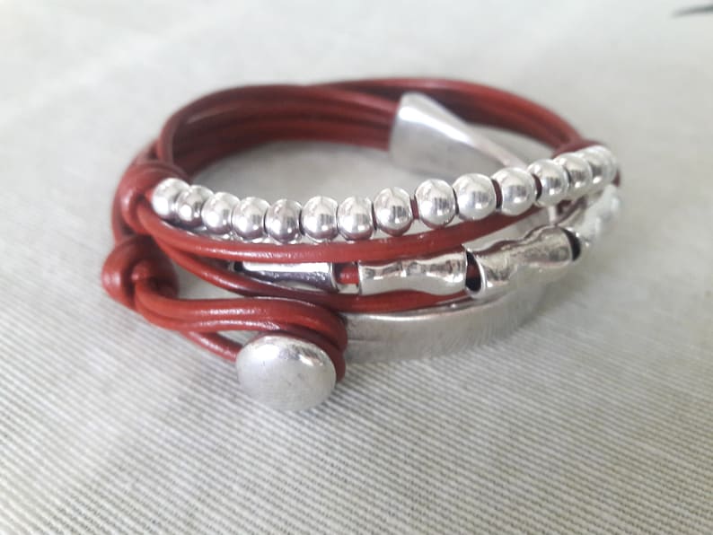 May include: A brown leather wrap bracelet with silver beads and metal accents.