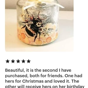 Peut inclure: Une bouteille en verre transparent avec un couvercle argent&eacute; et un ruban blanc. La bouteille pr&eacute;sente un motif d'abeille et de nid d'abeille avec des accents jaunes, bruns et noirs. La bouteille est d&eacute;cor&eacute;e d'un petit charme en forme de c&oelig;ur argent&eacute;.