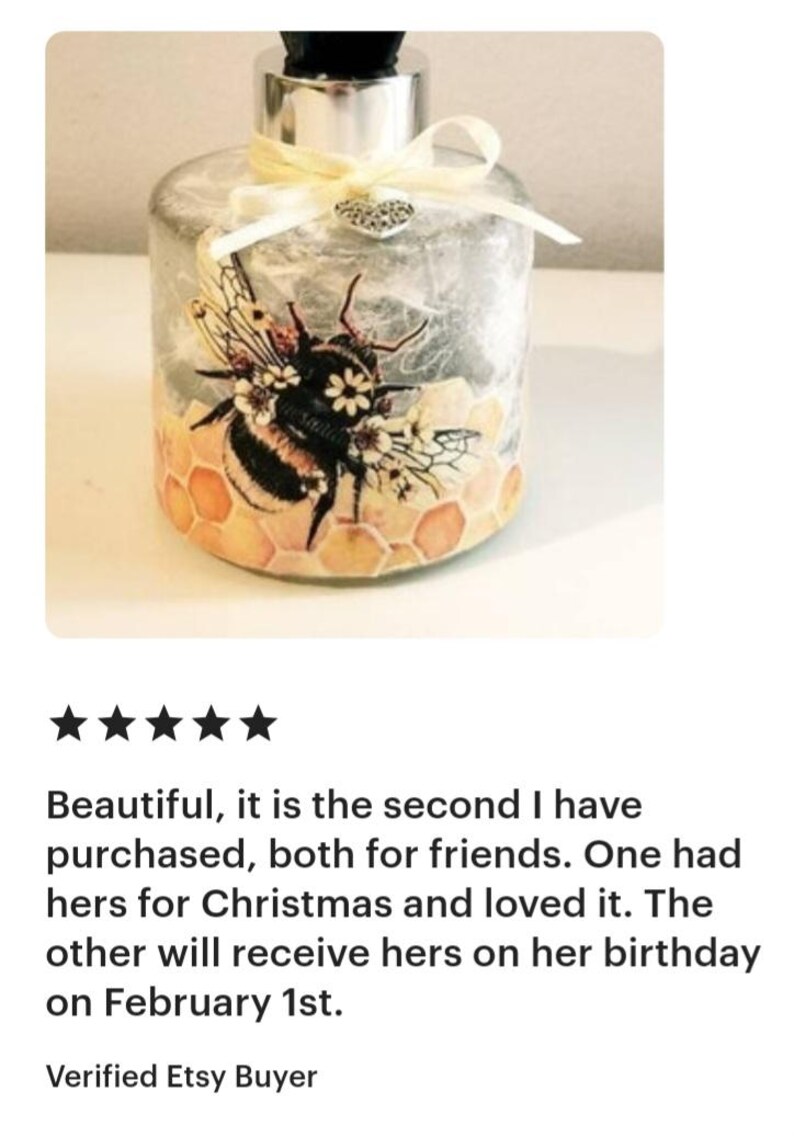 Peut inclure: Une bouteille en verre transparent avec un couvercle argent&eacute; et un ruban blanc. La bouteille pr&eacute;sente un motif d'abeille et de nid d'abeille avec des accents jaunes, bruns et noirs. La bouteille est d&eacute;cor&eacute;e d'un petit charme en forme de c&oelig;ur argent&eacute;.