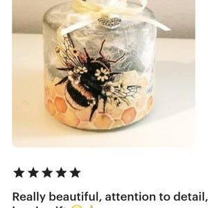 Peut inclure: Une bouteille diffuseur en verre transparent avec un couvercle argent&eacute; et un ruban jaune. La bouteille pr&eacute;sente un motif d&eacute;coratif d'une abeille avec du miel et des fleurs.