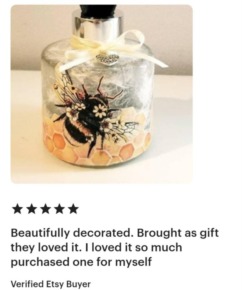 Peut inclure: Une bouteille diffuseur en verre transparent avec un couvercle argent&eacute; et un motif d'abeille d&eacute;coratif. L'abeille est entour&eacute;e de nids d'abeilles et de fleurs. La bouteille est attach&eacute;e avec un ruban blanc et un charme de c&oelig;ur argent&eacute;.