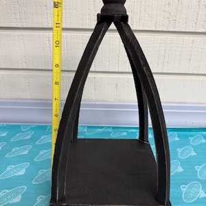 May include: A black wooden decorative lantern with a square base and arched sides, measuring approximately 11 inches tall. The top features a decorative finial. The lantern is painted black and has a rustic appearance.