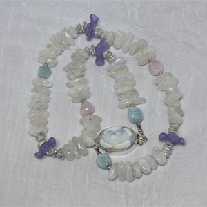 May include: A white moonstone necklace with a silver clasp and a variety of gemstone accents, including lavender, pink, and blue.