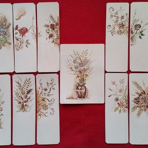 Puede incluir: Un conjunto de 15 marcap&aacute;ginas en blanco con dise&ntilde;os florales pintados a mano. Los marcap&aacute;ginas son blancos con ilustraciones florales marrones y verdes. Los dise&ntilde;os incluyen una variedad de flores, hojas y tallos.