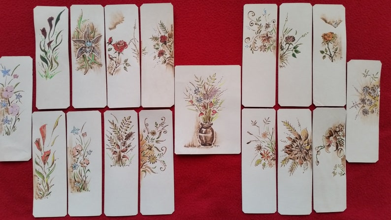 Puede incluir: Un conjunto de 15 marcap&aacute;ginas en blanco con dise&ntilde;os florales pintados a mano. Los marcap&aacute;ginas son blancos con ilustraciones florales marrones y verdes. Los dise&ntilde;os incluyen una variedad de flores, hojas y tallos.