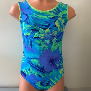 May include: A blue and green leotard with a floral print. The leotard has a scoop neck and a sleeveless design.