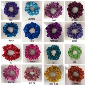 May include: A collection of colorful scrunchies in various shades, including purple, aquamarine, orchid, and raspberry. Each scrunchie is made of a shiny fabric and labeled with its color name. The scrunchies are arranged in a grid pattern.