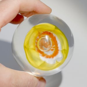 Vintage glass paperweight with yellow flower and air bubble, 70s