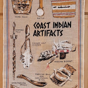 May include: A linen tea towel featuring illustrations of Coast Indian artifacts, including a Haida mask, rattle, shaman's pole, Nootka basket, medicine bonnet, and canoe. The towel has a beige background with blue and red borders.