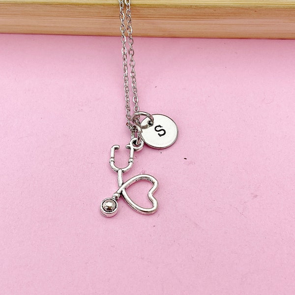 Può includere: Collana d'argento con ciondolo stetoscopio e cuore, e un piccolo ciondolo rotondo con la lettera 'S'.
