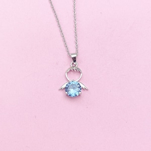 May include: A silver necklace with a blue crystal pendant shaped like an angel with outstretched wings.