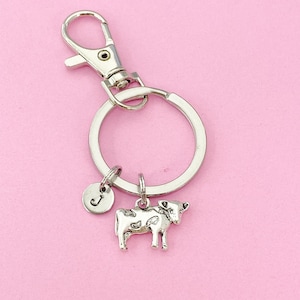 May include: Silver cow keychain with a silver letter J charm attached to a silver key ring.