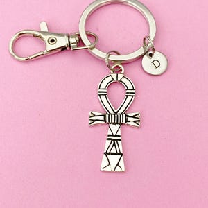 May include: Silver key chain with a silver ankh charm and a silver charm with the letter D.