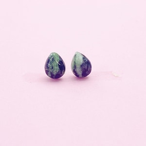 May include: A pair of teardrop-shaped earrings with a green and black marbled pattern.