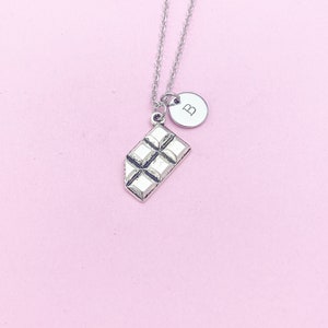May include: Silver necklace with a chocolate bar charm and a letter 'B' charm.