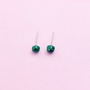 May include: A pair of silver stud earrings with green malachite stones.