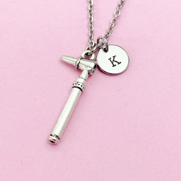Può includere: Collana d'argento con un piccolo ciondolo a forma di martello d'argento e un ciondolo a disco d'argento con la lettera K incisa.