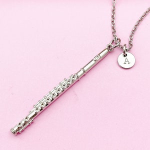 May include: A silver flute charm necklace with a silver initial charm that says "A" on a pink background.