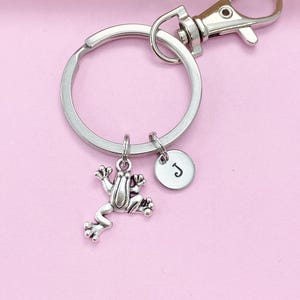 May include: Silver keychain with a frog charm and a silver disc charm with the letter J on it.