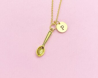 May include: A gold necklace with a spoon charm and a small round charm with the letter "P" engraved on it.