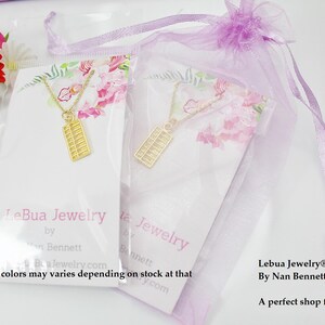 May include: Two white cards with the text "LeBua Jewelry by Bennett" and "Lebua Jewelry&reg;, Inc. By Nan Bennett A perfect shop for everyone!"  Each card features a gold abacus necklace on a purple and white background.