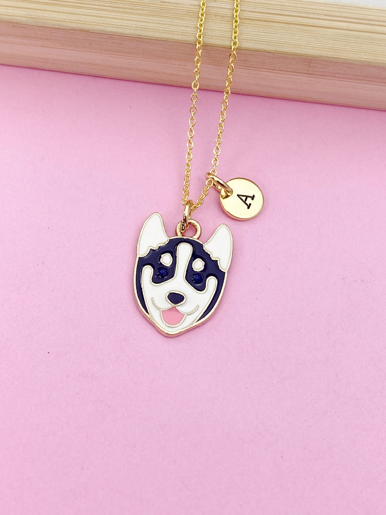 May include: Gold chain necklace with a black and white husky dog charm and a gold initial charm with the letter "A".