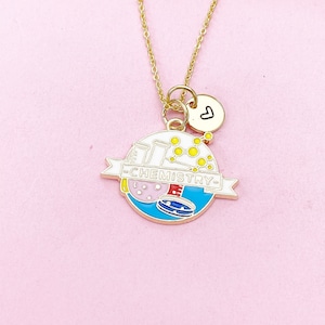 May include: Gold necklace with a charm that says "CHEMISTRY" and features a beaker, test tubes, and molecules. The charm also has a small heart charm attached to it.
