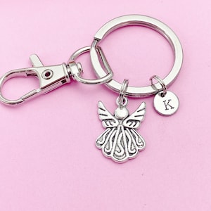 May include: Silver angel charm keychain with a silver letter K charm. The keychain has a silver split ring and a silver lobster clasp.
