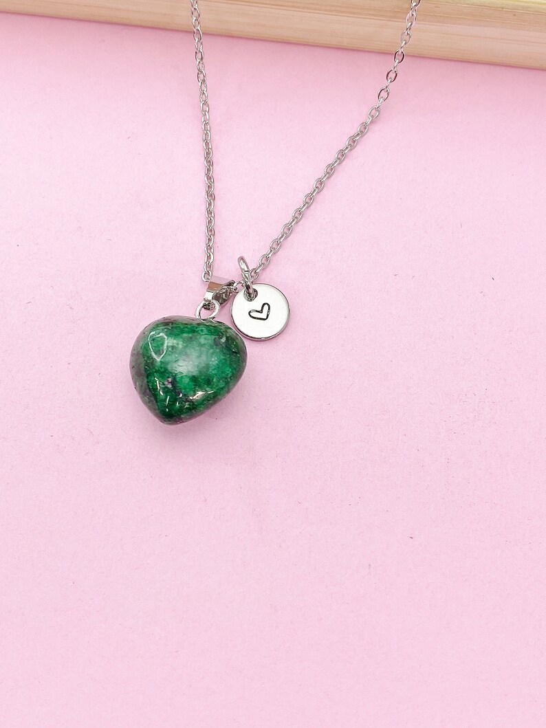 May include: A silver chain necklace with a green heart-shaped pendant and a small silver charm with a heart engraved on it.