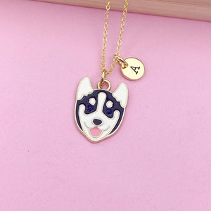 May include: A gold chain necklace with a black and white husky dog charm and a gold initial charm with the letter "A".