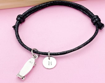 May include: Black adjustable cord bracelet with a silver skateboard charm and a silver charm with the letter H.