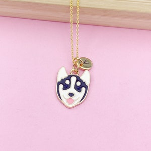 May include: Gold chain necklace with a black and white husky charm and a gold initial charm. The initial charm is a letter A.