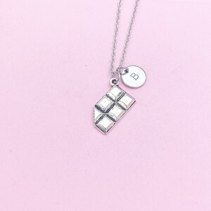 May include: A silver necklace with a chocolate bar charm and a silver disc charm with the letter "B" on it.
