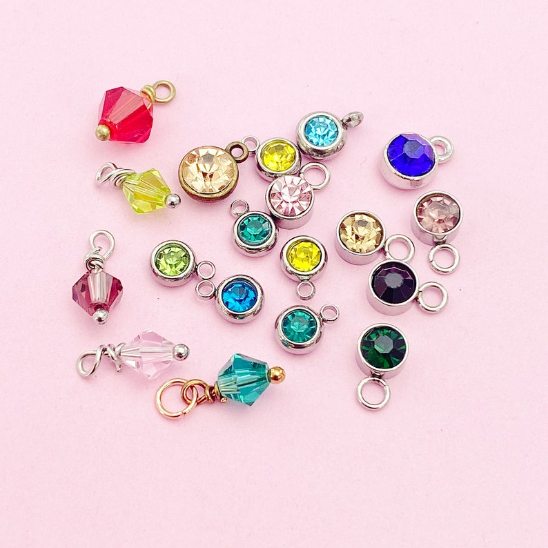May include: Assortment of colorful crystal charms with various shapes and sizes. The charms are made of glass and metal and are perfect for jewelry making.