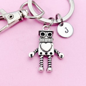May include: Silver robot keychain with a heart on its chest and a silver letter 'J' charm attached to a silver key ring.
