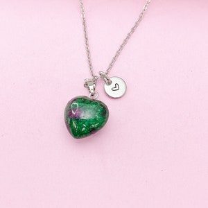 May include: A silver chain necklace with a green and pink heart-shaped pendant and a small silver charm with a heart engraved on it.