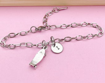 May include: A silver chain bracelet with a skateboard charm and a charm with the letter "I" on it.