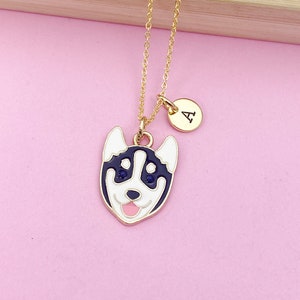 May include: A gold chain necklace with a black and white husky charm and a gold initial charm with the letter "A".