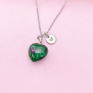 May include: A silver chain necklace with a green heart-shaped pendant and a small silver charm with a heart symbol.