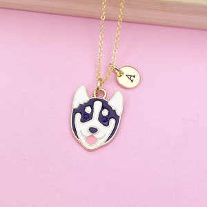 May include: A gold chain necklace with a black and white husky dog charm and a gold initial charm with the letter "A".