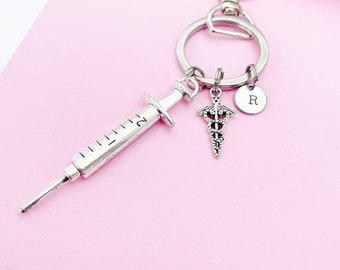 May include: Silver keychain with a syringe charm, a medical caduceus charm, and a charm with the letter "R" on it.