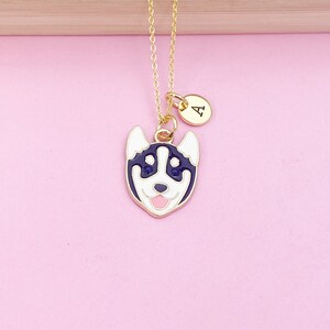 May include: Gold chain necklace with a black and white husky dog charm and a gold initial charm with the letter "A".