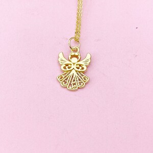 May include: A gold angel pendant necklace with a delicate, intricate design. The pendant features a detailed angel with wings and a halo. The necklace is on a thin gold chain.