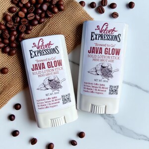 Peut inclure: Deux bâtonnets de lotion solide Java Glow "Velvet Expressions" blancs, avec des grains de café éparpillés. Chaque bâtonnet porte du texte et un dessin de grains de café. Le poids net est de 14g.