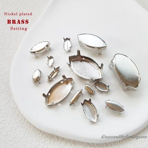 May include: Nickel plated brass settings for rhinestones or other embellishments. The settings are oval shaped and come in a variety of sizes.