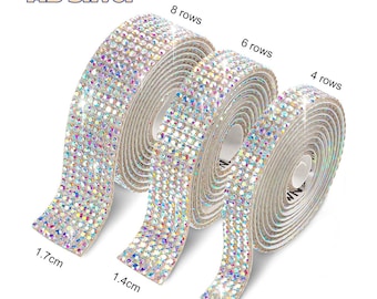 May include: Three rolls of AB Silver rhinestone trim in different widths. The rolls are 1.7 cm, 1.4 cm, and 1 cm wide. Each roll has 8, 6, and 4 rows of rhinestones, respectively.